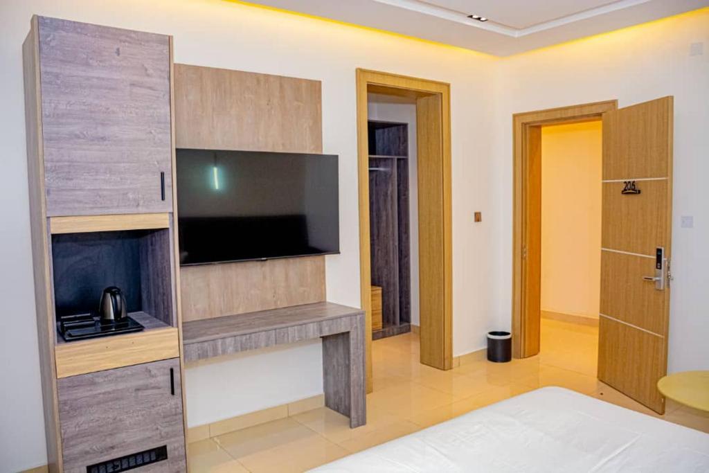 ein Wohnzimmer mit einem Flachbild-TV und einem Kamin in der Unterkunft Polo Grand Hotel in Maiduguri