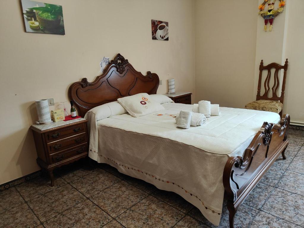 a bedroom with a large bed with a wooden headboard at vilaboa - servicio de habitaciones in Bóveda