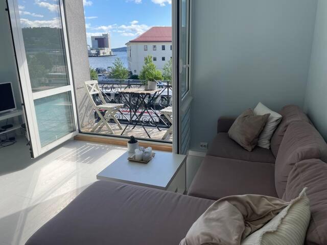 d'un salon avec un canapé et une vue sur un balcon. dans l'établissement K. West, à Kristiansand