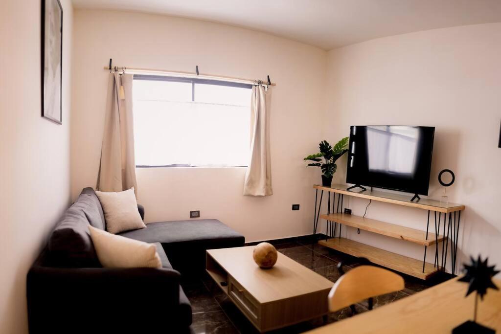 Casa Amma - Dharma في ماتيوالا: غرفة معيشة مع أريكة وتلفزيون