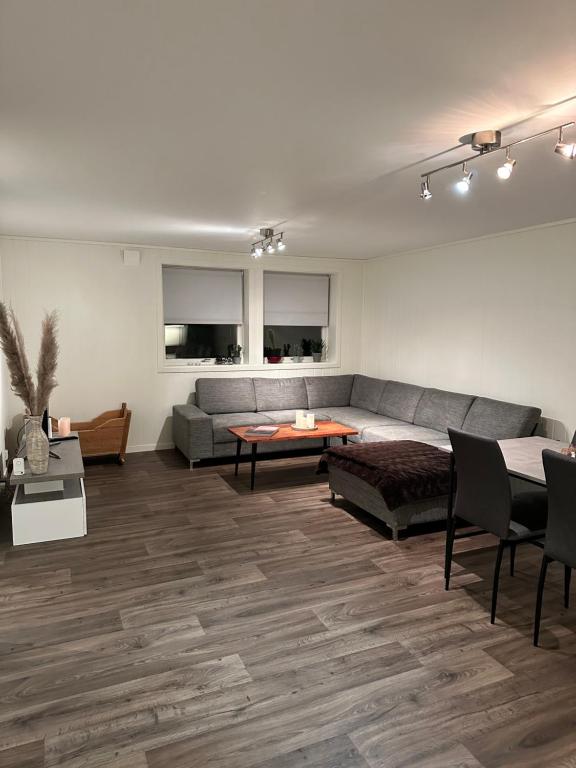 salon z kanapą i stołem w obiekcie Your home away from home, apartment 2 w mieście Tromsø