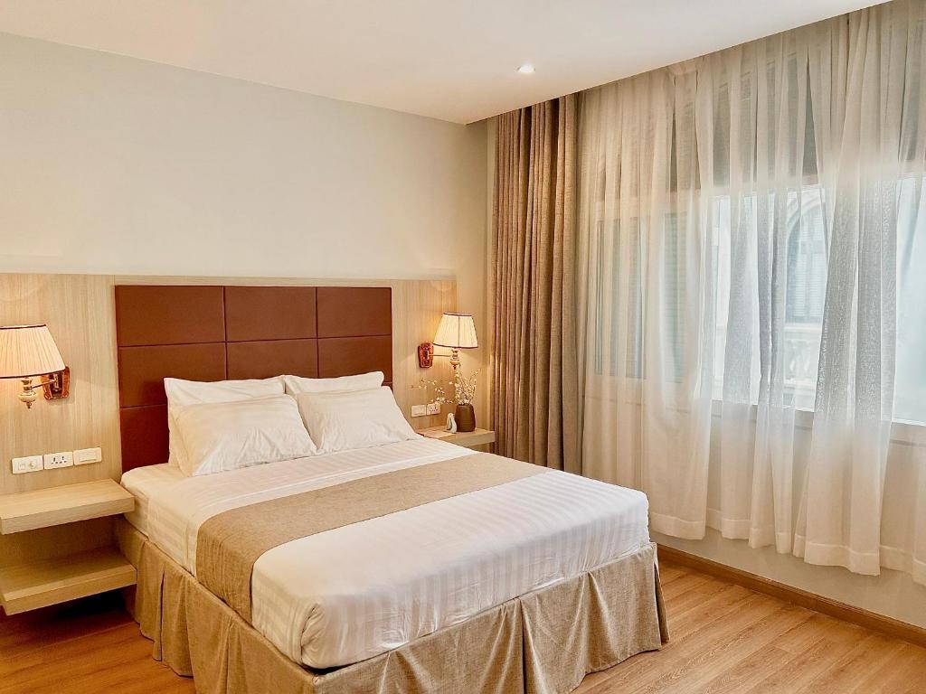 a bedroom with a large bed and a window at Plouton Hotel in Phú Quốc