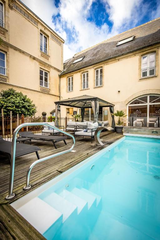 une piscine devant un immeuble dans l'établissement Grand Hôtel du Luxembourg & Spa, à Bayeux