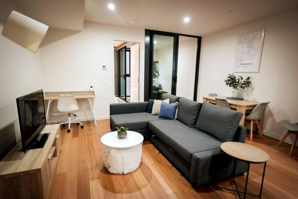 sala de estar con sofá y mesa en Braddon 1BR Apt, WiFi, Secure Parking, AMAZING LOCATION en Canberra