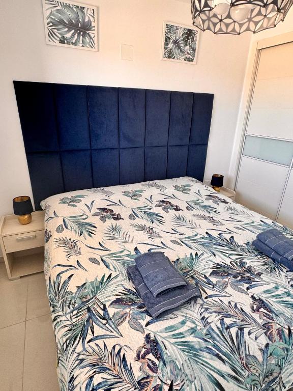 sypialnia z łóżkiem z niebieskim zagłówkiem w obiekcie Apartamento Sea Senses, Punta Prima w mieście Torrevieja