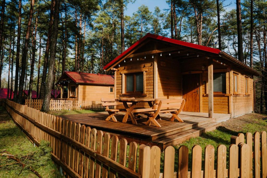 a wooden cabin with a picnic table and a fence at Wypoczywanko Domek 43, 45 in Borsk