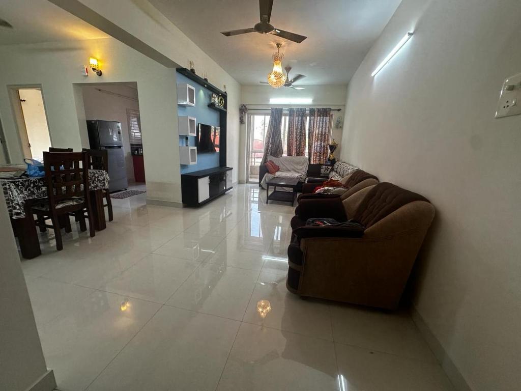 uma sala de estar com um sofá e uma lareira em Garden Club em Mangalore