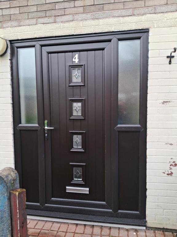 a black door with four pictures on it at 4 mereside walk in Manchester