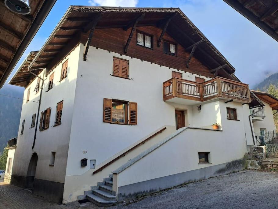 a white building with a wooden balcony on it at casetta in montagna in Mocenigo