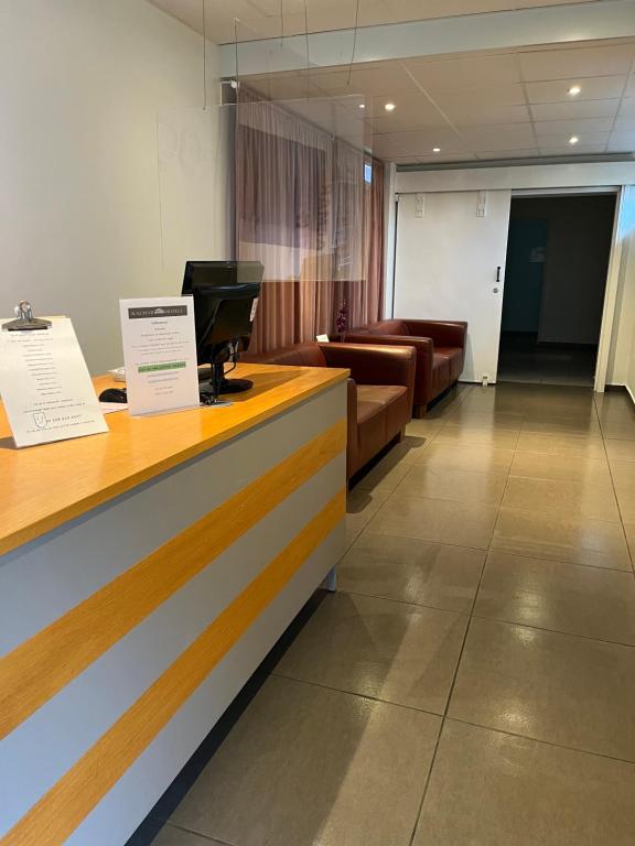 a reception desk in a waiting room with couches at Kalmar Hotell in Kalmar