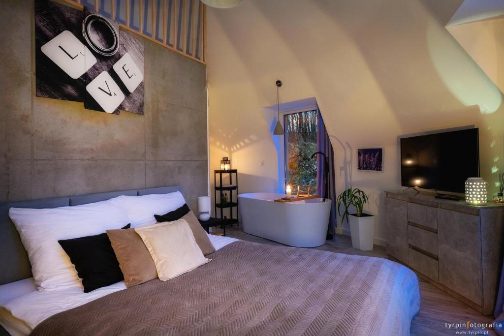 um quarto com uma cama, uma banheira e uma televisão em Bunkier House 