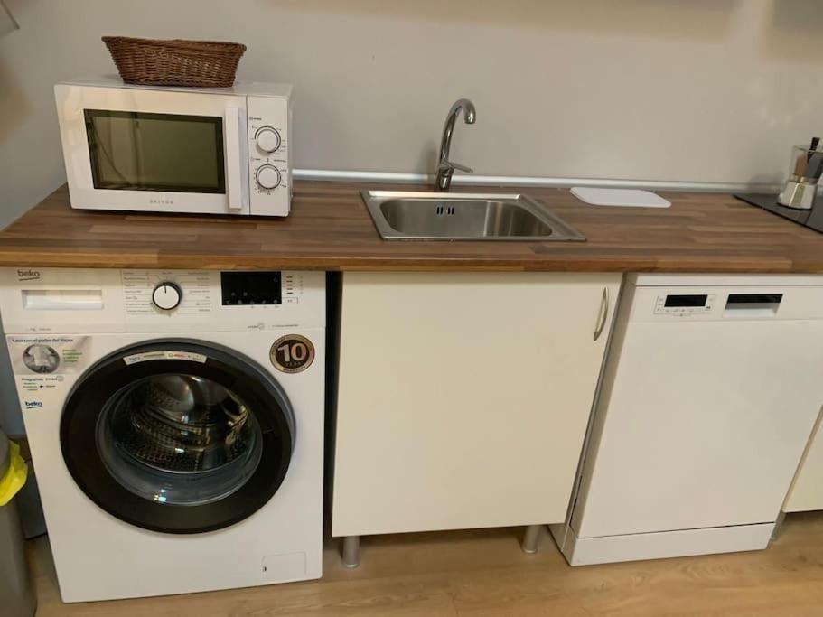 a kitchen with a microwave and a washing machine at Studio in Barrio Salamanca (D) in Madrid