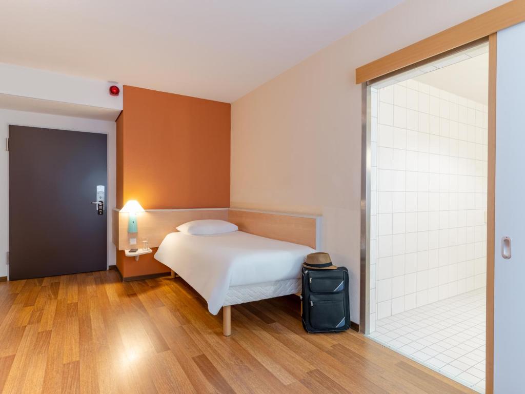 um quarto com uma cama e uma porta de vidro deslizante em ibis Stuttgart Centrum em Stuttgart