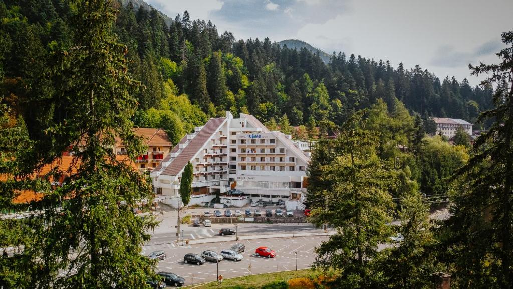 un gran edificio en medio de un estacionamiento en Hotel Tusnad, en Băile Tuşnad