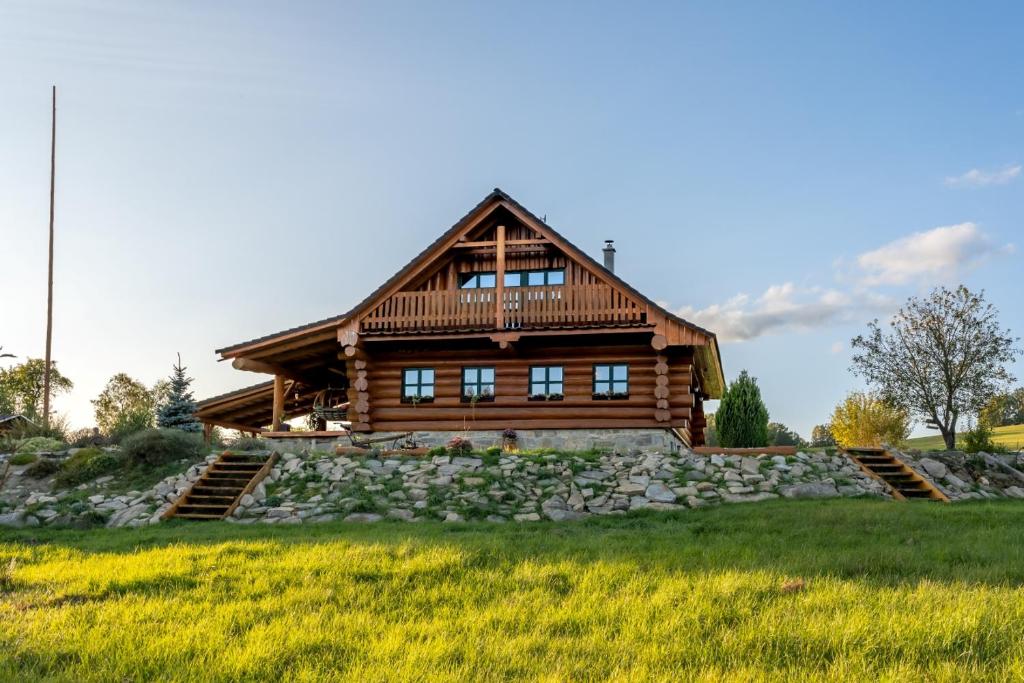 a log cabin on a hill with a grass field at Srub Pohodář v Novohradských horách in Benešov nad Černou