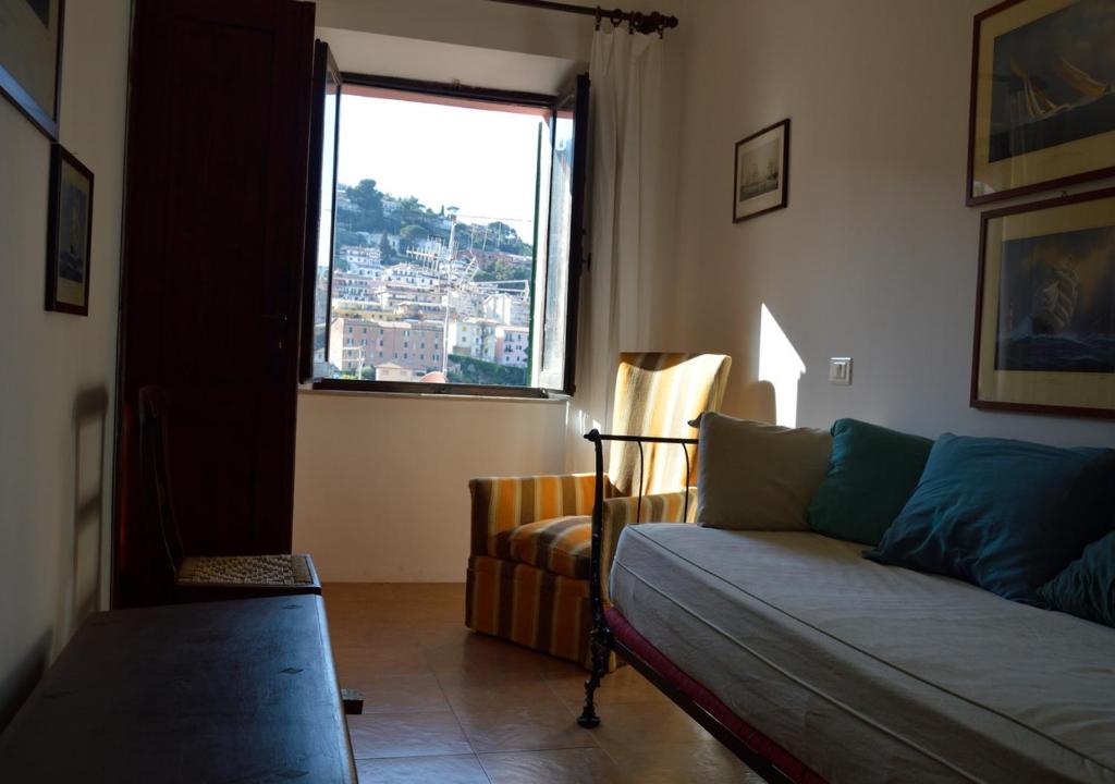 a living room with a couch and a window at STELLA HOUSE in Porto Santo Stefano
