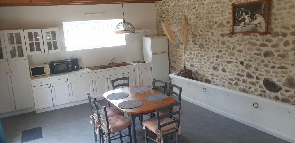 - une cuisine avec une table et des chaises dans la chambre dans l'établissement Maison en pierres à 1200m de la mer, à Agon-Coutainville