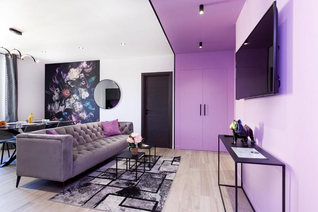 - un salon avec des murs violets et un canapé dans l'établissement Somptueux 4 pièces Foch - Centre Cannes et proche Palais des Festivals, à Cannes