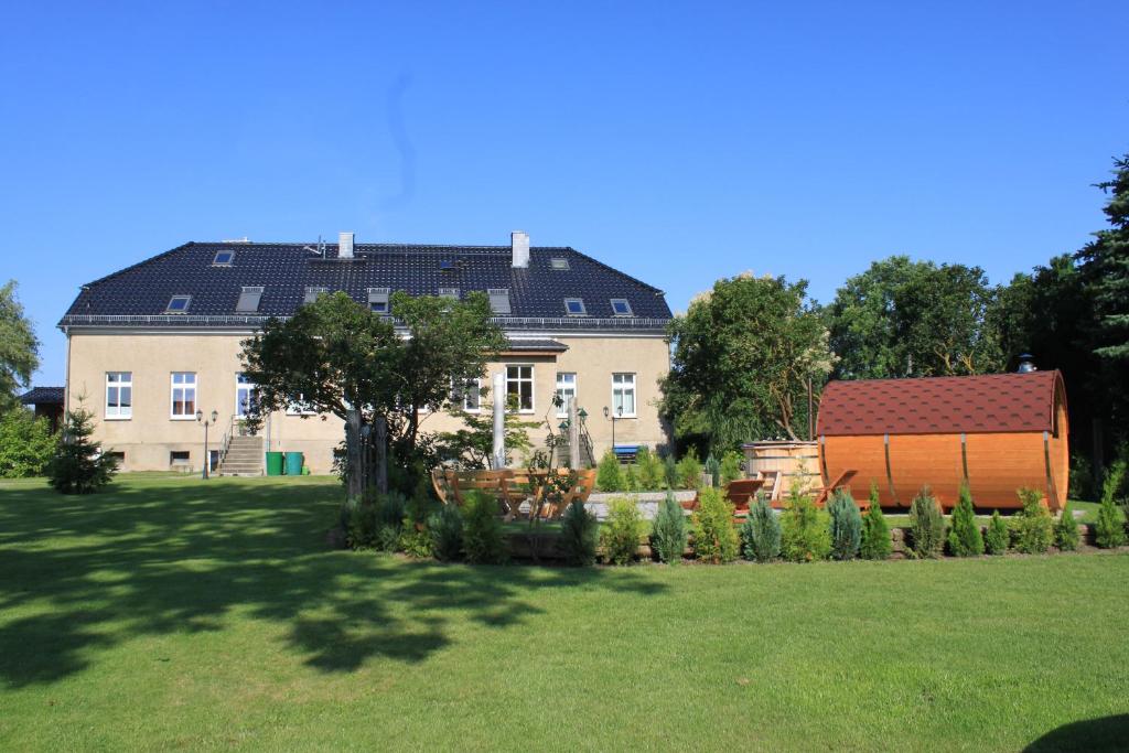 a large house with a garden in front of it at Ferienwohnung im Gutshaus Mühlhof in Prenzlau