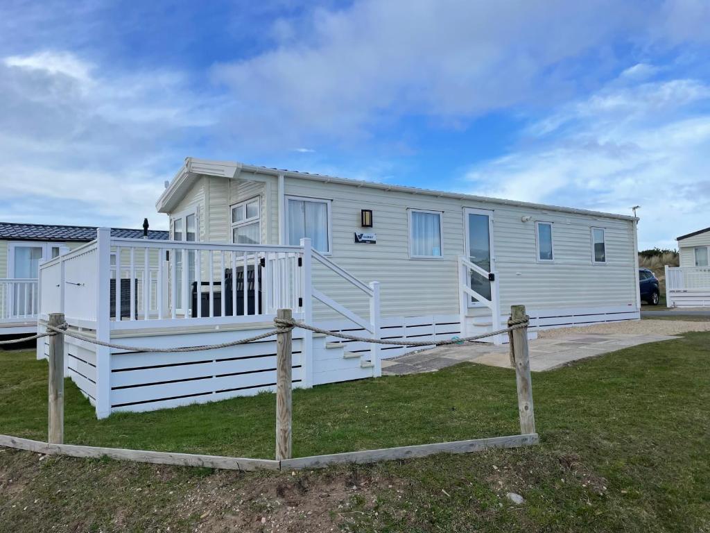 a large white mobile home with a porch at Fairview Caravan Hire in Lossiemouth