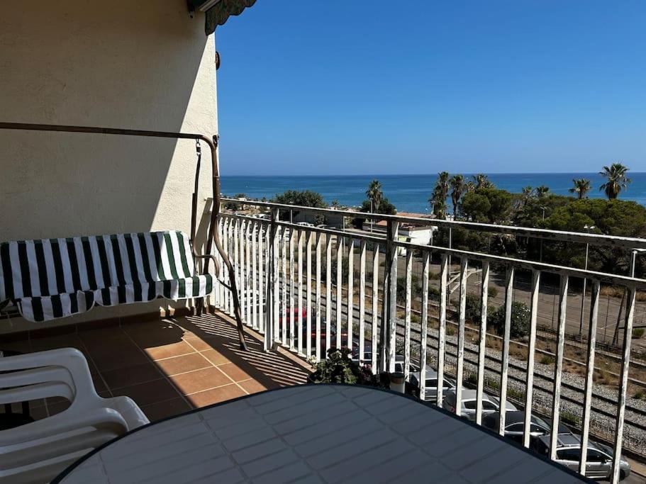 a balcony with a table and chairs and the ocean at Apartamento a primera línea de Mar in Pineda de Mar
