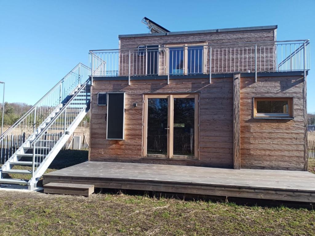 ein Holzhaus mit einer Terrasse und einer Treppe in der Unterkunft Holzhaus am Bergheider See 