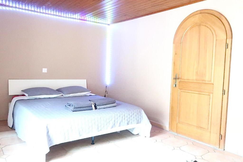 um quarto com uma cama e uma porta de madeira em City Garni em Martigny-Ville