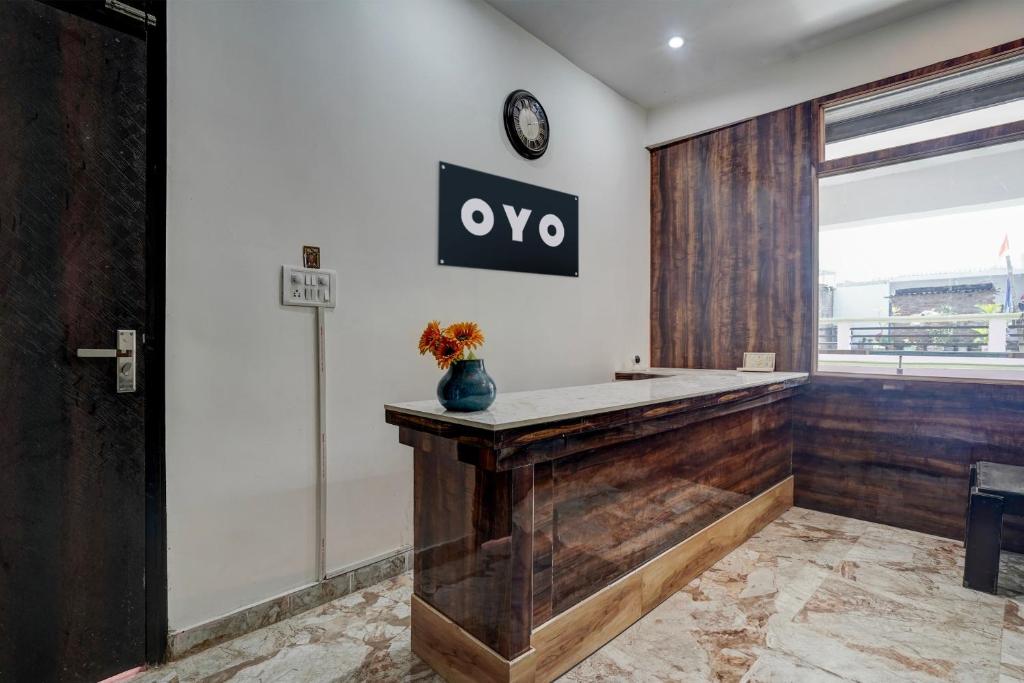 a lobby with a counter with a clock on the wall at OYO Flagship Swastik Inn in Lucknow