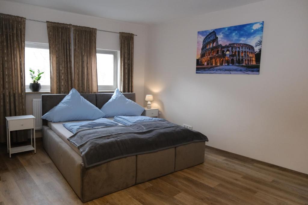 a bedroom with a bed with blue pillows on it at Schloss Casa Lauf an der Pegnitz Rom in Lauf an der Pegnitz