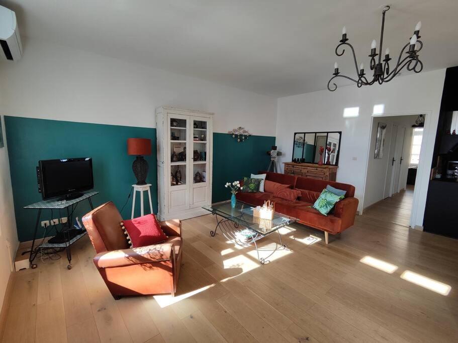 un salon avec deux canapés et une télévision dans l'établissement Le Grand Carnot, à Sète