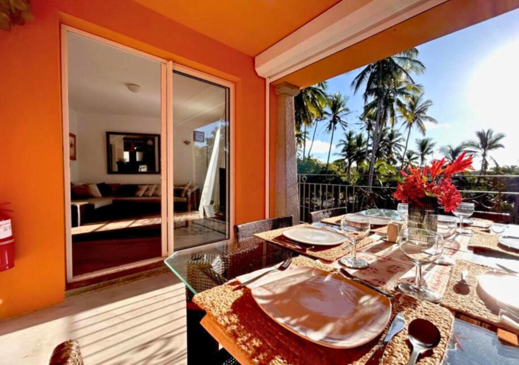 uma sala de jantar laranja com uma mesa e uma varanda em Scenic Riverfront 2 Bedroom Villa in Port Chambly em Baie du Tombeau