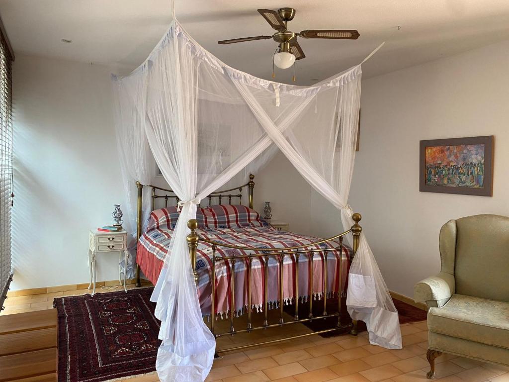 a bedroom with a canopy bed with a ceiling fan at Corgos, Lagarto in Monchique