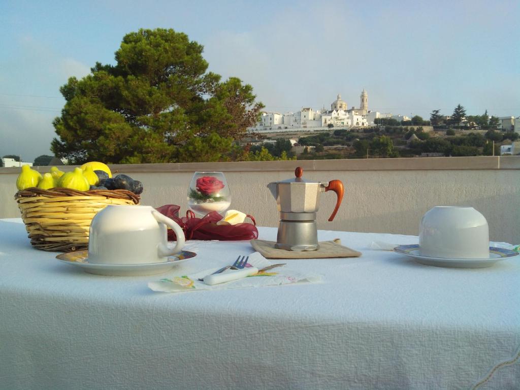 een witte tafel met een fruitmand en een theepot bij DIMORA ANTONIANNA in VALLE D'ITRIA in Locorotondo