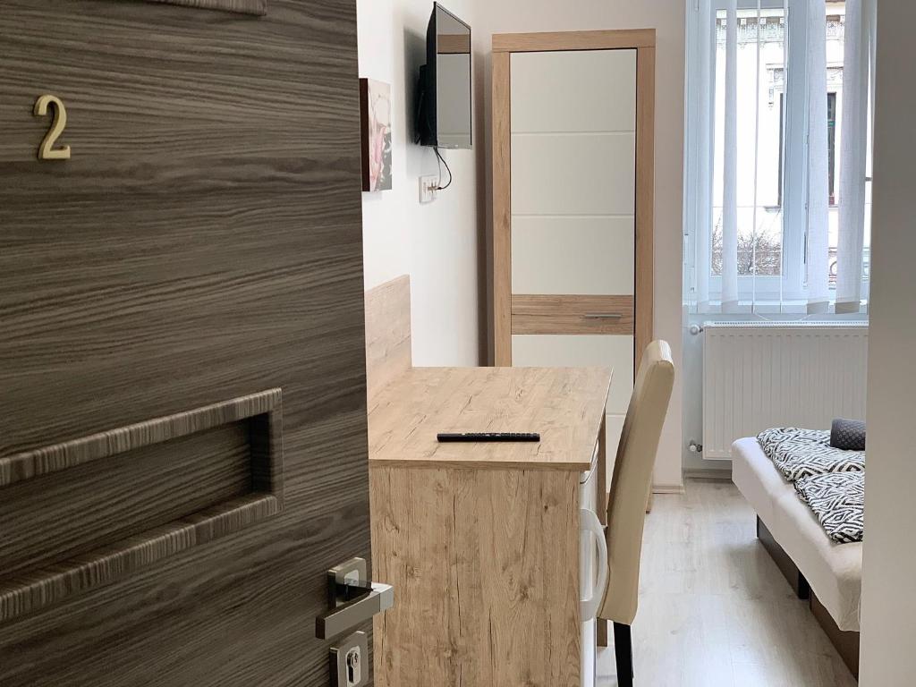 a room with a desk with a television on a wall at Tiny Apartments in Miskolc