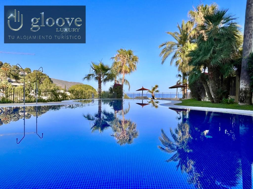 uma piscina com palmeiras e um céu azul em Mar y Montana House by Gloove em Altea