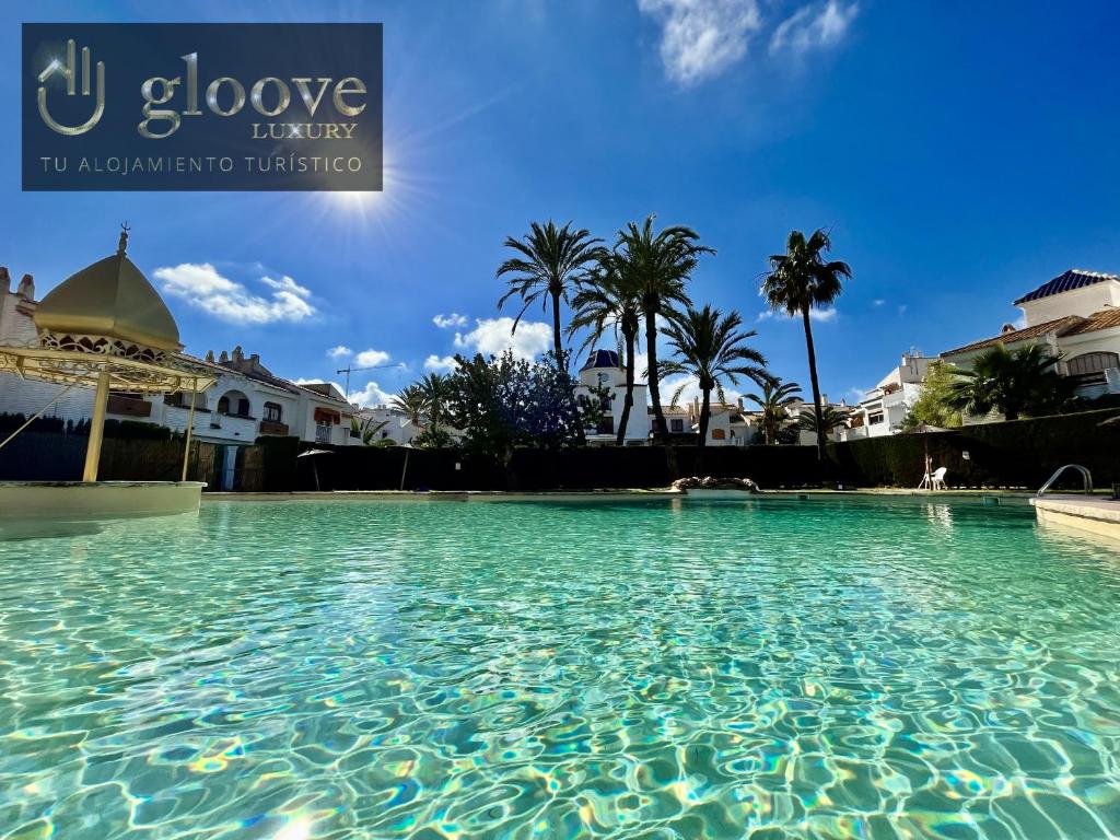 una gran piscina en un complejo con palmeras en Relaxing Sea Views by Gloove, en Alicante