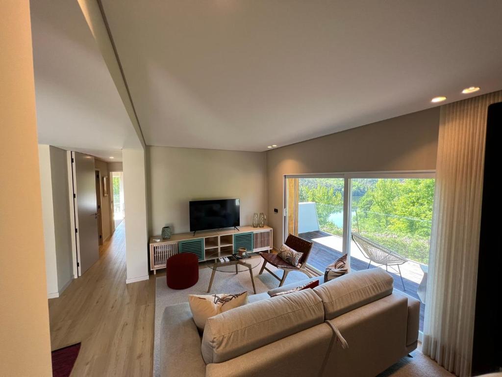 uma sala de estar com um sofá e uma televisão em Casas Bouça Maria - Aqua Village & Sports em Marco de Canavezes
