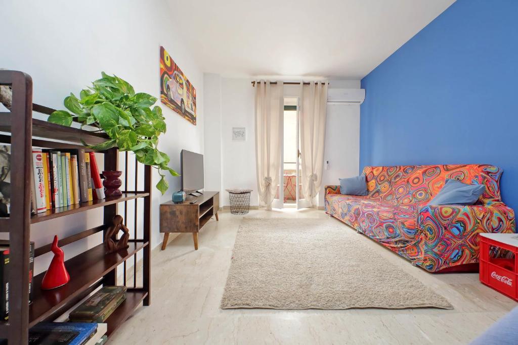 een woonkamer met een bank en een boekenplank bij Casa Trastevere in Rome