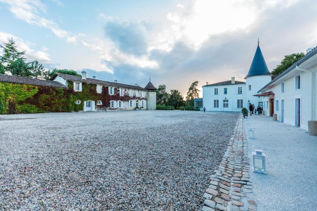 a cobblestone street with buildings and a church at Gîte Château de Seguin in Lignan-de-Bordeaux