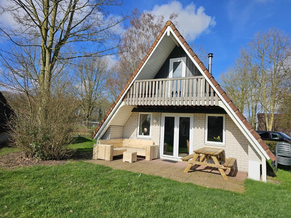 een klein huis met een picknicktafel ervoor bij 6 pers. vakantiehuis aan visvijver op vakantiepark, Time4vacay in Gramsbergen