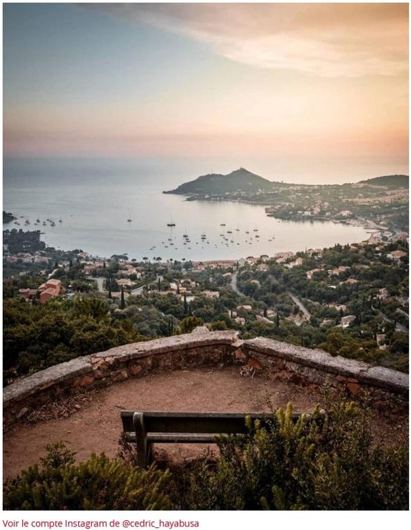 a bench sitting on top of a hill overlooking the ocean at &quot;Location Vue MER et ESTEREL&quot;, Cap Estérel Agay-Saint Raphaël, T2, piscines, parking, wifi in Saint-Raphaël