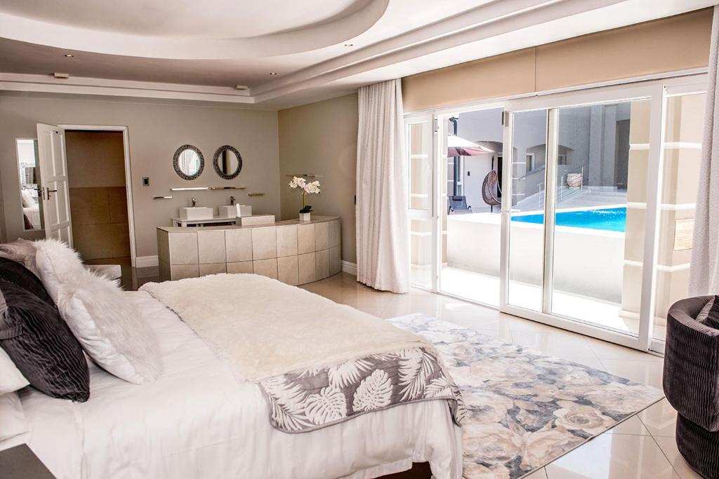 a bedroom with a bed and a view of a pool at K Partners' Boutique Hotel & Spa in Langebaan