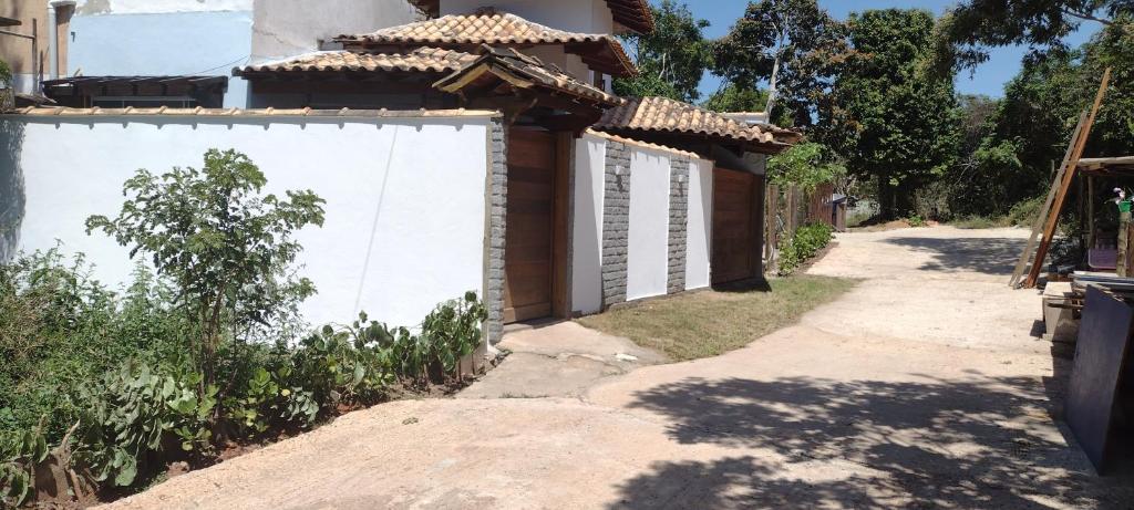 a house with a white wall next to a road at Casa Mar in Armacao dos Buzios