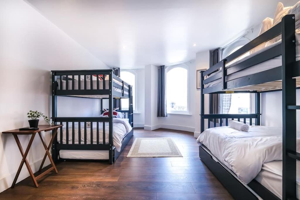 Cette chambre comprend 2 lits superposés et une table. dans l'établissement Quaint and Spacious Piccadilly Sleep 6 VRD, à Londres