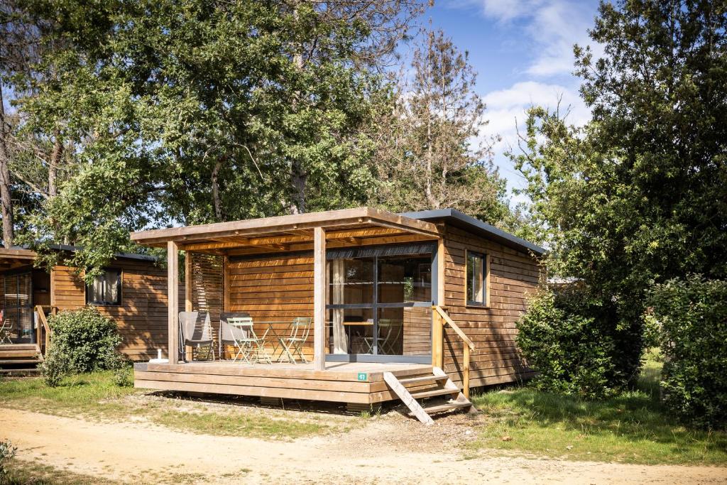 Cabaña de madera con porche y terraza en Camping La Pinède en Excenevex