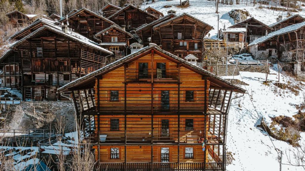 a large wooden house in the snow with snow at Alloggio in antica frazione Walser in Alagna Valsesia