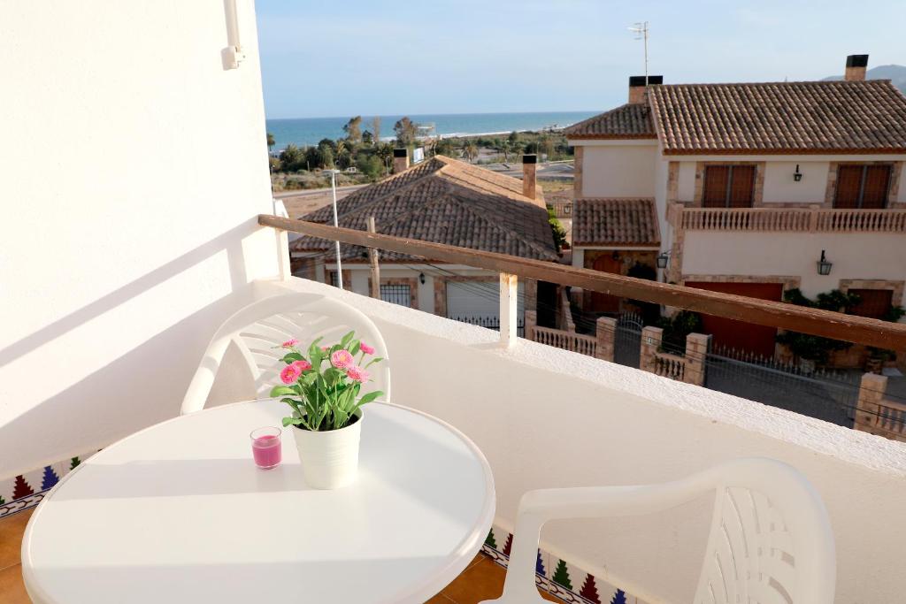 uma mesa branca e cadeiras numa varanda com vista em Apartamento Luna Llena Golf de San Juan de los Terreros em San Juan de los Terreros