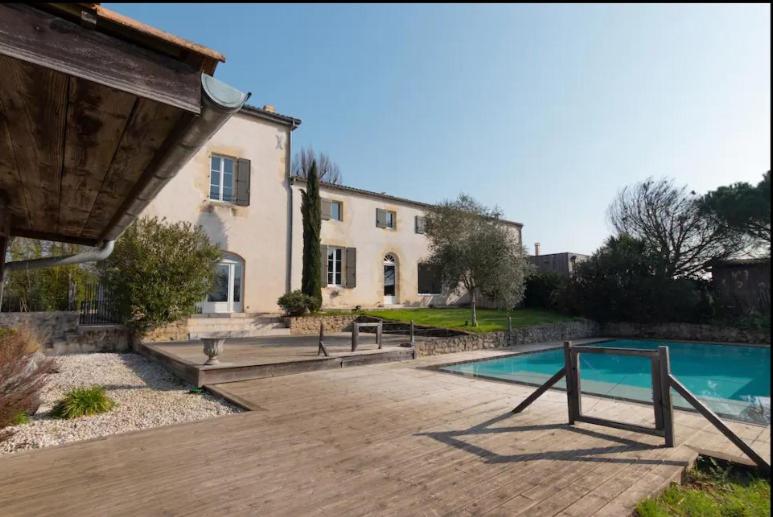 une maison avec une piscine devant une maison dans l'établissement Château Caillivet au cœur d'un vignoble Bio pour 2 à 6 personnes, à Mazères