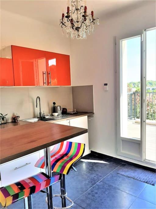 une cuisine avec des placards rouges et un comptoir en bois dans l'établissement Appartement avec terrasse entre Versailles et Paris, à Marnes-la-Coquette