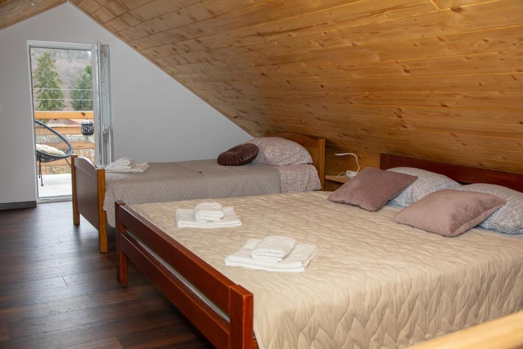 twee bedden in een kamer met houten wanden bij Medeni raj in Mače